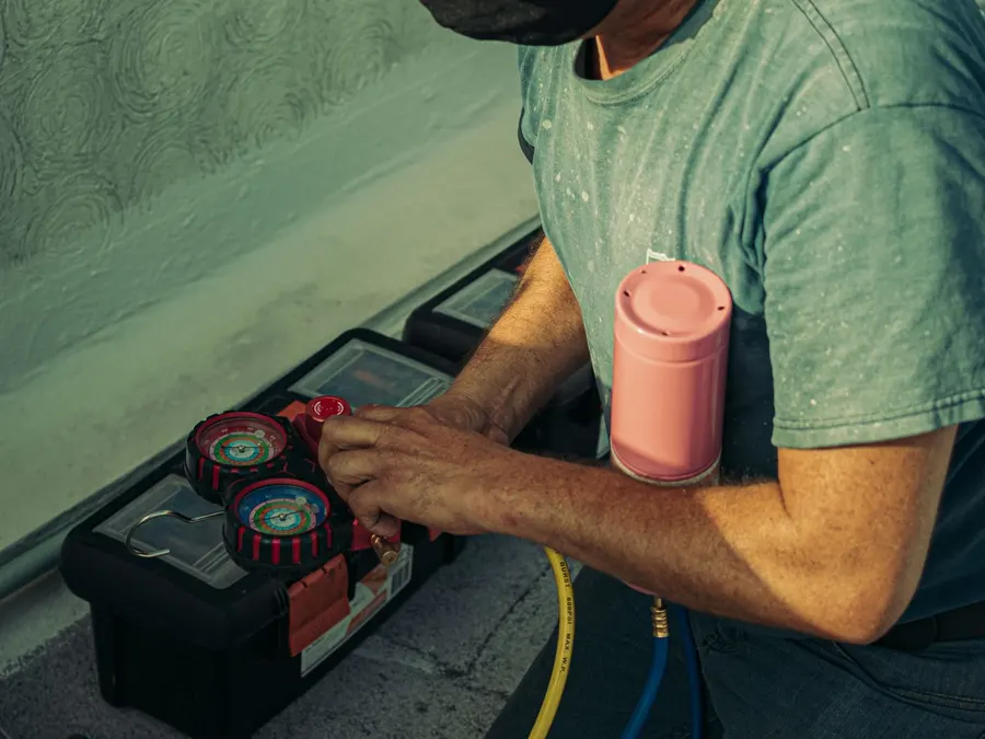 HVAC technician preparing tools and gauges for an air conditioning installation